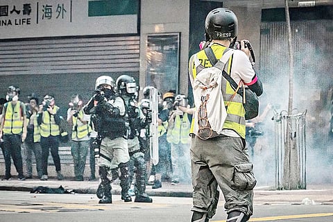 UNDER fire A photojournalist faces a wall of shields in Hong Kong.