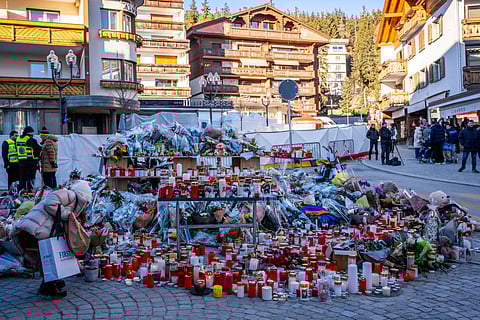 SWITZERLAND-ACCIDENT-FIRE
A mourner lays a flower bouquet at a makeshift memorial near the Constellation bar, on January 4, 2026, in Crans-Montana in honour of the victims of the fire that ripped through the venue in the luxury Alpine ski resort on New Year's Eve. Authorities investigating the New Year's blaze in the Swiss resort of Crans-Montana have identified 24 of the 40 people killed, including 11 minors and six foreign nationals, police said on January 4, 2026. Also 119 were injured during the fire, most of them seriously, according to the latest toll.

