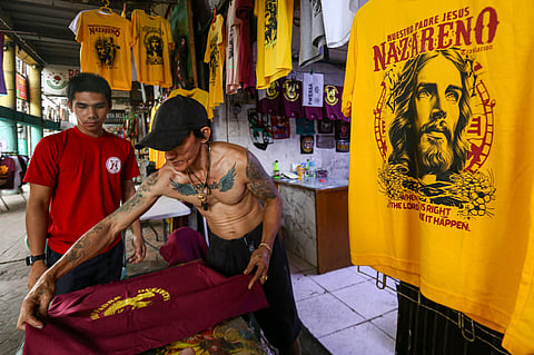 A T-shirt seller prints images of Jesus Nazareno at his shop along Alfonso Mendoza Street, Manila on Sunday ahead of the Feast of the Black Nazarene. The shirts are sold between P150 and P200.