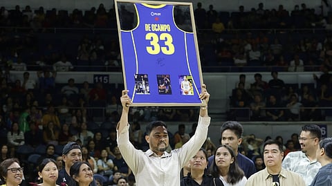 RANIDEL de Ocampo proudly shows off the framed jersey of TNT during retirement rites at halftime of the PBA Philippine Cup game Friday between TNT and Meralco.