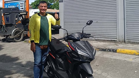 GRAND prize winner William Lloyd Leala from Tacloban City stands beside the motorcycle he received through Maxim’s Christmas Rewards Program.