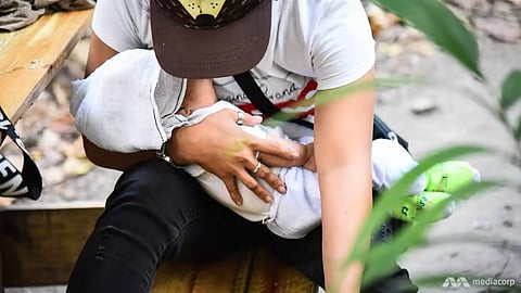 A FILIPINO mother holds her two-month-old baby near the Port of Manila. Authorities are investigating cases of parents attempting to sell infants online.