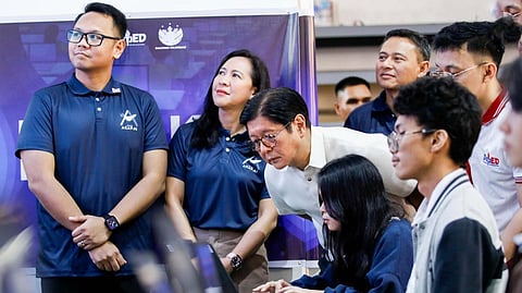 PRESIDENT Ferdinand R. Marcos Jr. (leaning over in a white shirt) inspects a student’s work during the launch of the Department of Education’s Project AGAP.AI at the Quezon City Science High School, a move to integrate artificial intelligence into basic education and national development by training students, teachers, and parents in the responsible and ethical use of AI.