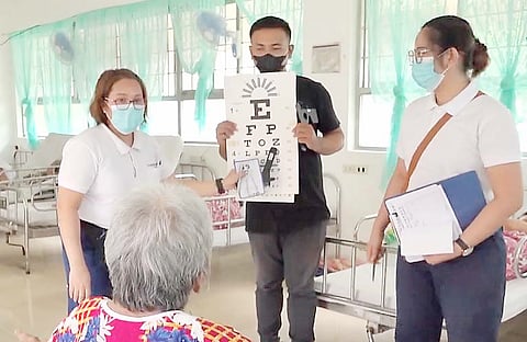 A RESIDENT of Haven for the Elderly reads an eye chart.