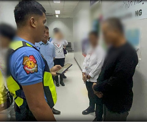 MEMBERS of the PNP Aviation Security Group and airport security interrogate the suspected cellphone thief at the arrival lobby of NAIA Terminal 3 on Thursday.
