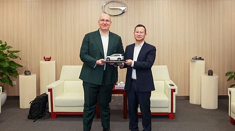 EXECUTIVES from Grab and GAC exchange a scale model electric vehicle as a symbol of their collaboration on EV deployment and in-vehicle system integration. Shown are (left): Philipp Kandal, chief product officer at Grab, was presented a car model from Xia Xianqing, president of GAC Group.