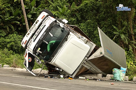 A six-wheeler truck loaded with coconut lumber overturned along the Gumaca bypass road in Quezon on Tuesday. Bystanders said the vehicle lost balance due to the wet and slippery road conditions.
