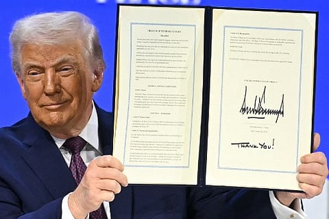 US President Donald Trump holds a signed founding charter at the "Board of Peace" meeting during the World Economic Forum (WEF) annual meeting in Davos on January 22, 2026.  