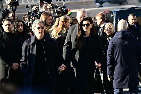 US actor Adam Shulman and US actress Anne Hathaway (R) arrive at the funeral ceremony for the late Italian fashion designer Valentino Gavarani at the Basilic of Santa Maria degli Angeli e dei Martiri, in Rome on January 23, 2026.
