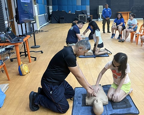 EMPOWERING EMERGENCY-READY COMMUNITIES. Dependents of Meralco employees are among the participants
of the Survival Boot Camp led by the Meralco Rescue Academy held at the Meralco Operating Center in Pasig. In photo
are young participants training to administer the cardiopulmonary resuscitation (CPR) procedure.
