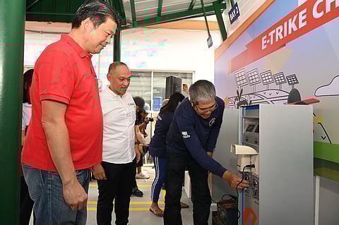 A member of MULCETRODA shows Cong. Kenneth Gatchalian (in red) and OMF President Jeffrey Tarayao (in white) how his e-trike battery
can recharge through the new e-charging station
