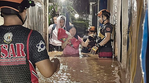 MEMBERS of the local government’s rescue team guide residents out of their flooded homes in Barangay Bugo as tropical storm ‘Basyang’ continues its onslaught in Mindanao.