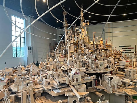 ‘DWELLINGS,’ a large-scale installation art made up of cardboard featuring images of houses and buidlings, towers, roads and villages by Filipino contemporary artists Alfredo and Isabel Aquilizan.