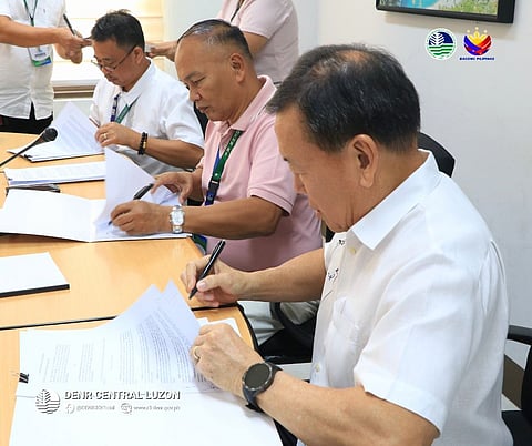DENR3 Regional Director Ralph Pablo (middle) sign a MOA with V On Wings, Inc. and DENR officials for the adoption and greening of a 32.51-hectare land in Doña Remedios Trinidad, Bulacan.