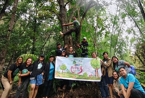 Tree Huggers with a Cause — PENRO Iloilo staff wrap their arms around tree trunks at the Maasin Watershed Forest Reserve in Iloilo, turning a simple embrace into a strong statement of solidarity and renewed commitment to safeguard the province’s remaining forest cover.