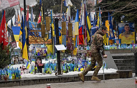 A WOUNDED Ukrainian serviceman walks past makeshift memorial for fallen Ukrainian and foreign soldiers on Independence Square in Kyiv amid the Russian invasion of Ukraine.
