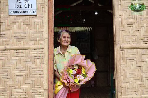 REGINA Amotan, 89, holds Valentine’s Day flowers given by Tzu Chi volunteers at her new home also donated by the humanitarian organization in Sagbayan, Bohol on 14 February 2026. 