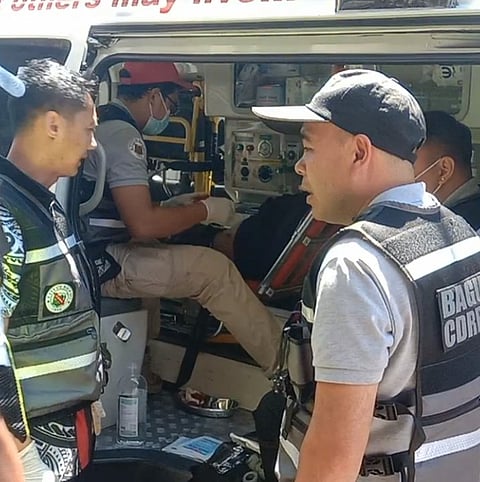 Responders attend to a vagrant man who incurred a minor injury from the bullet that ricocheted after he fired a gun he earlier snatched from a female police officer after the Grand Float Parade in Baguio City. Photo Courtesy of Dionisio Dennis.