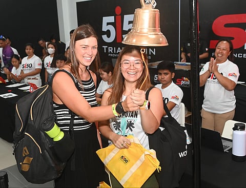 BELGIAN triathlete Lorie Verstick (left) joins Filipina Darlyn Ty in ringing the ceremonial bell during Friday’s registration for the 5150 Triathlon Guimaras.
