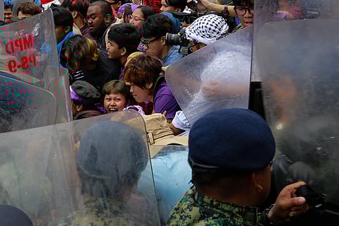 Women activists and allies from Gabriela push against police barricades on Kalaw Avenue in Manila, Sunday, 08 March, 2026. The group marched toward the US Embassy on International Women’s Day to protest US-Israeli military actions involving Iran.