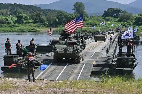 A US Stryker infantry carrier vehicle crosses a river over a floating bridge during a joint South Korea-US river-crossing drill in Yeoju, as part of the annual Ulchi Freedom Shield exercise.