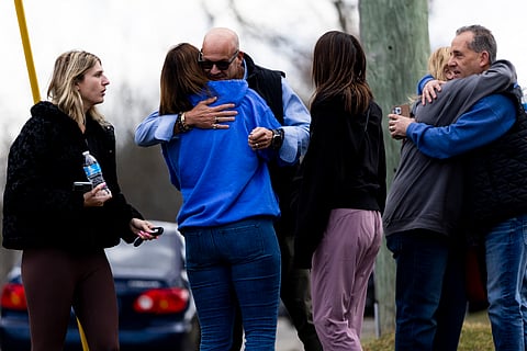 WEST BLOOMFIELD, MICHIGAN - MARCH 12: Employees and their families reunite after law enforcement escorts them back to their cars following an active shooter near Temple Israel on March 12, 2026 in West Bloomfield, Michigan. According to authorities a suspect is dead after ramming a vehicle into the Detroit-area synagogue. Police continue to investigate as emergency personnel remained on the scene. 
