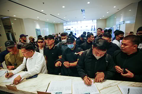 SUBPOENA SHOWDOWN. Lawyer Levito Baligod, accompanied by several alleged former Marines, arrives at the National Bureau of Investigation headquarters in Pasay City on Thursday, 12 March 2026, after being subpoenaed over allegations that they delivered suitcases of cash to Ferdinand Marcos Jr., former House Speaker Martin Romualdez and other lawmakers.