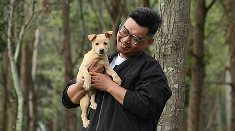 A PET owner holds his dog in a park, reflecting the close bond between Filipinos and their pets as Maxicare launches its PRIMA Animal Bite Care e-voucher aimed at providing accessible treatment and protection against animal bite incidents.