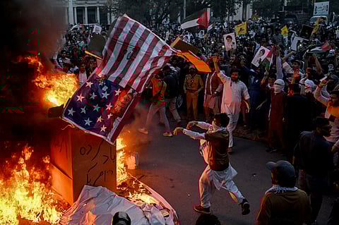 Pakistani Shia Muslims burn the US national flag, during a rally to mark Al-Quds Day (Jerusalem), a commemoration held annually on the last Friday of the Islamic holy fasting month of Ramadan, in Lahore on 13 March 2026.
