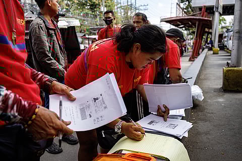 Tricycle drivers help each other as they fill out forms for the Department of Social Welfare and Development's cash aid program, in Paco, Manila on Monday, 16 March 2026.

DSWD will begin the rollout of P5,000 financial assistance to tricycle drivers in 39 designated payout centers in Metro Manila as a response to surging oil prices.