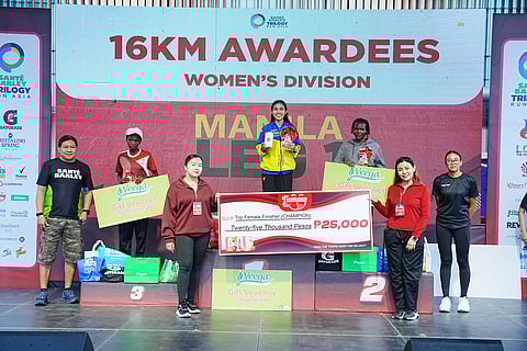 EDNA Magtubo celebrates at the podium after ruling the women’s division of the Sante Barley Trilogy Run Asia 2026 Manila Leg 1 on Sunday at SM Mall of Asia Grounds.