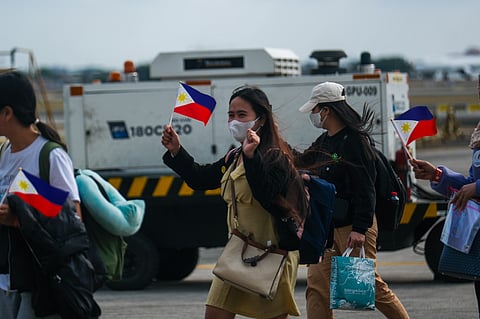 UNEXPECTED homecoming Nearly 400 Filipinos aboard government-chartered flights from the United Arab Emirates arrive at Villamor Air Base in Pasay City Thursday afternoon. Department of Migrant Workers Secretary Hans Cacdac and OWWA administrator PY Caunan welcome the third batch of arrivals as deployments continue amid rising tensions in the region.
