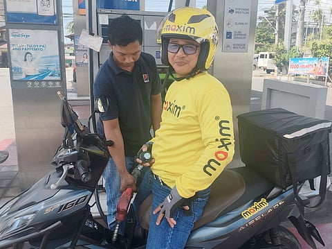 RIDER refuels his motorcycle with support from Maxim’s fuel voucher program amid rising fuel prices.