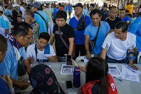 Jeepney drivers not on the government’s ₱5,000 cash relief master list line up at a court near Manila City Hall on Wednesday, 25 March 2026, asking the Department of Social Welfare and Development to include their names. DSWD says they will not receive the aid today but promised a special payout.
