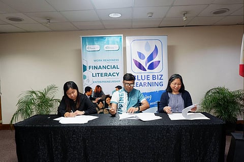Paula Patrice Dela Cruz of JA Philippines, Executive Director Krishna Alejandrino of JA Philippines, and Emilie Grace Nolledo Tan, Founder of Blue Biz Learning, formalize their partnership during the signing ceremony in Makati City.