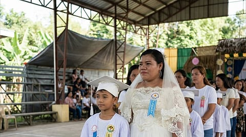 Mariveles matriarch Mary Grace Computo Gundayao wears her wedding gown during her son's graduation rites in Marivles, Bataan.