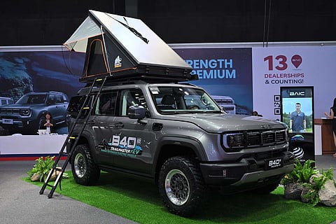 VISITORS check the BAIC B40e Trailmaster rEV on display with a rooftop tent at the MIAS 2026 booth.
