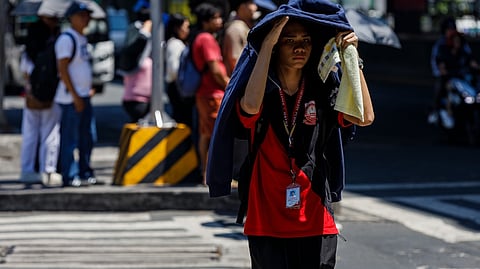 A PEDESTRIAN braves the midday heat while crossing the intersection of Taft Avenue and United Nations Avenue in Manila.