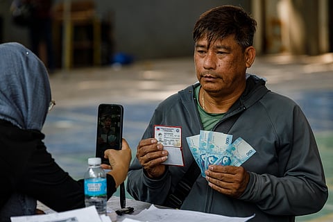 Tricycle drivers who were not included in the first batch of cash aid distribution queue to receive the P5,000 government subsidy during a special payout at a court in Malate, Manila last Tuesday, 14 April.