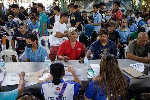 Tricycle drivers who were not included in the first batch of cash aid distribution, queue to receive the P5,000 government subsidy during a special payout at a court in Malate, Manila last Tuesday, 14 April.
