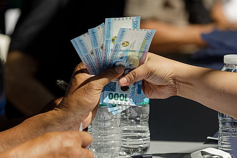 Jeepney drivers previously not included in the list of recipients for the subsidy line up to receive the P5,000 cash relief from the Department of Social Welfare and Development at a court in Sta. Cruz, Manila on Wednesday, 15 April 2026. 
