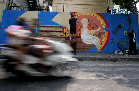 Muralists Kerry Villazor and Charlez Peñaredonda render their artistic touch on their entry for the WPS mural competition at Barangay Sta. Lucia, Quezon City