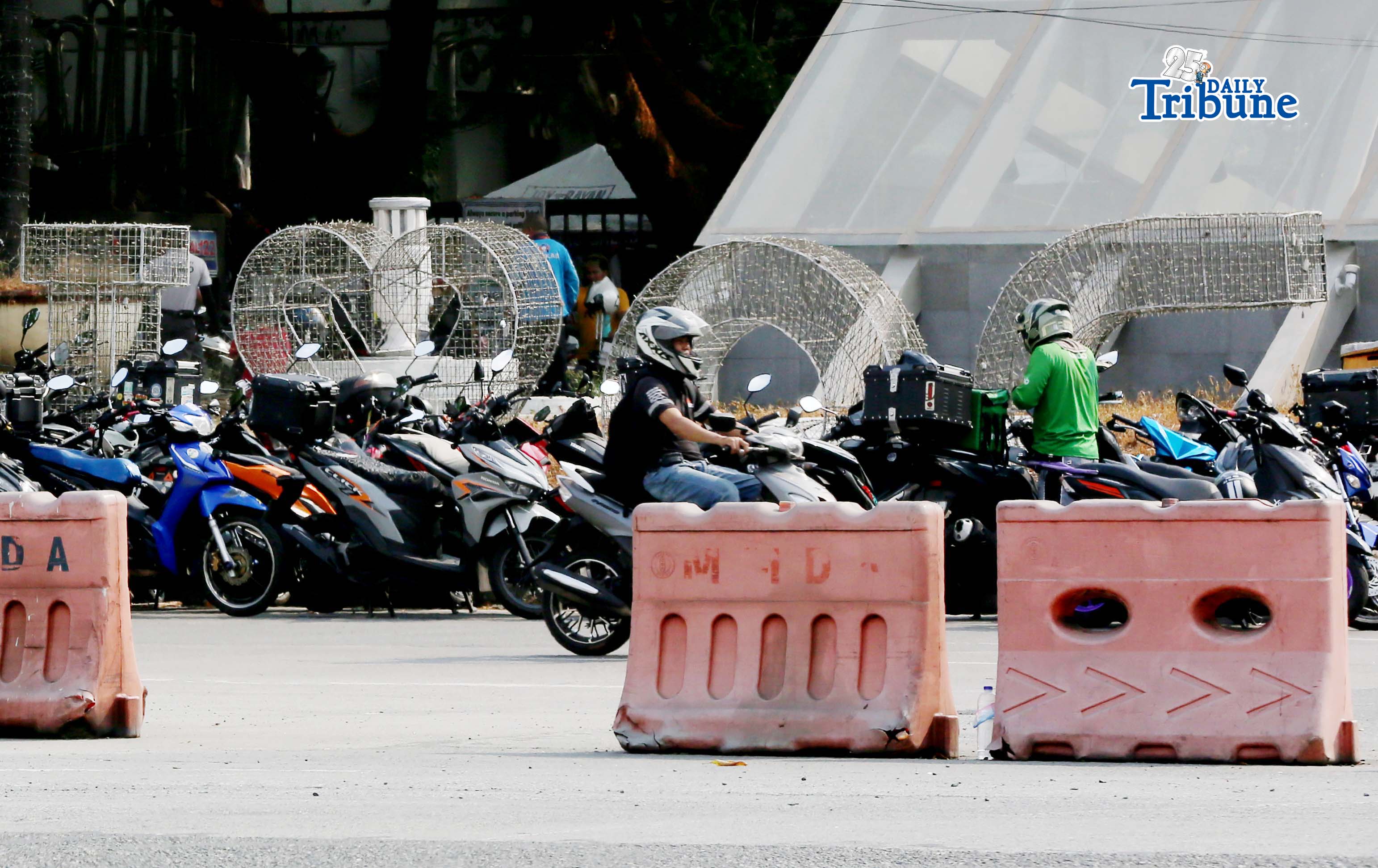 (April 17 2026) Motorcycles are parked at the entrance of the Quezon Memorial Circle in Quezon City as motorcycle taxi and delivery riders claim their P5,000 from Department of Social Welfare and Development (DSWD) personnel during a special payout schedule for unclaimed cash relief assistance on Friday April 17 2026. Photo/Analy Labor