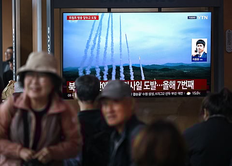 People watch a television screen showing a news broadcast with file footage of a North Korean missile test, at a train station in Seoul on April 19, 2026. North Korea test-fired multiple ballistic missiles on April 19, South Korea's military said, the latest in a recent flurry of launches by the nuclear-armed state.
