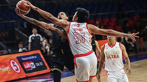 ARIS Dionisio of Titan Ultra blocks the layup of Damian Chonqui of Macau during their PBA Commissioner’s Cup game on Tuesday at the Ninoy Aquino Stadium.