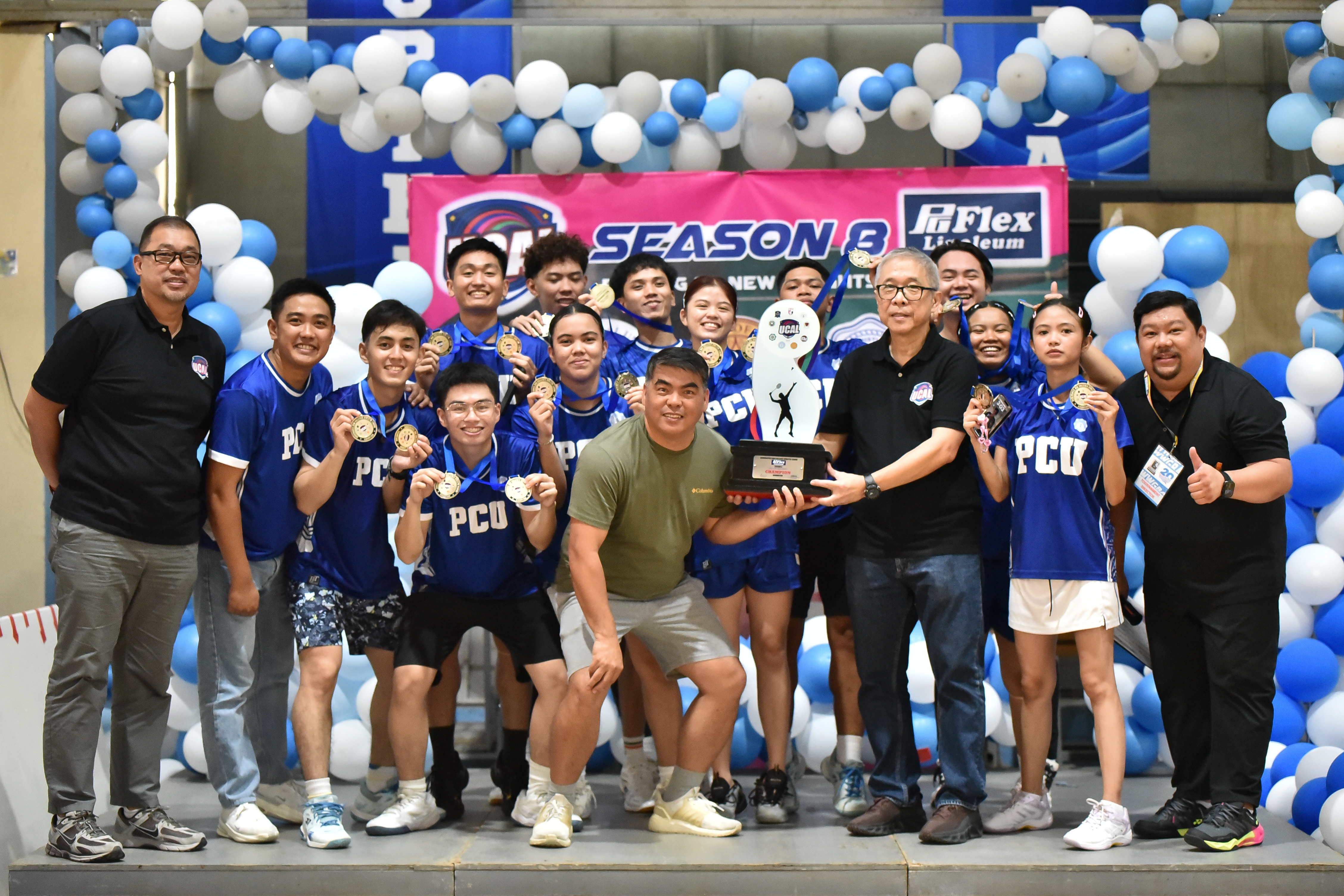 UCAL chairman Horacio Lim (right) hands the championship trophy to PCU-D management committee representative Johnny Belandrez after the Dolphins dominated the badminton tournament. Also shown are PCU players and UCAL chief finance officer Bernard Yang.