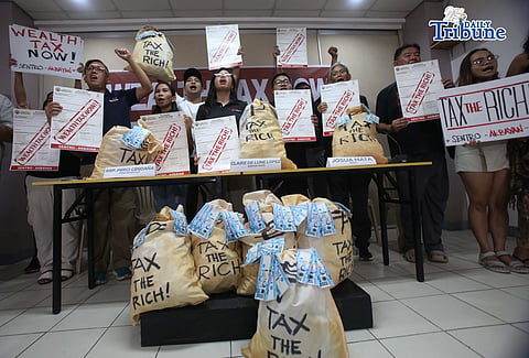 (April 30 2026) Ahead of Labor Day public and private sector workers, alongside the Akbayan Partylist and allied youth, hold a placard and a bundle of play money during the press conference on Thursday April 30 2026, as they called for the legislation and enforcement of wealth tax in conjunction with calls from other groups for a decrease in ordinary worker’s taxes. Photo/Analy Labor