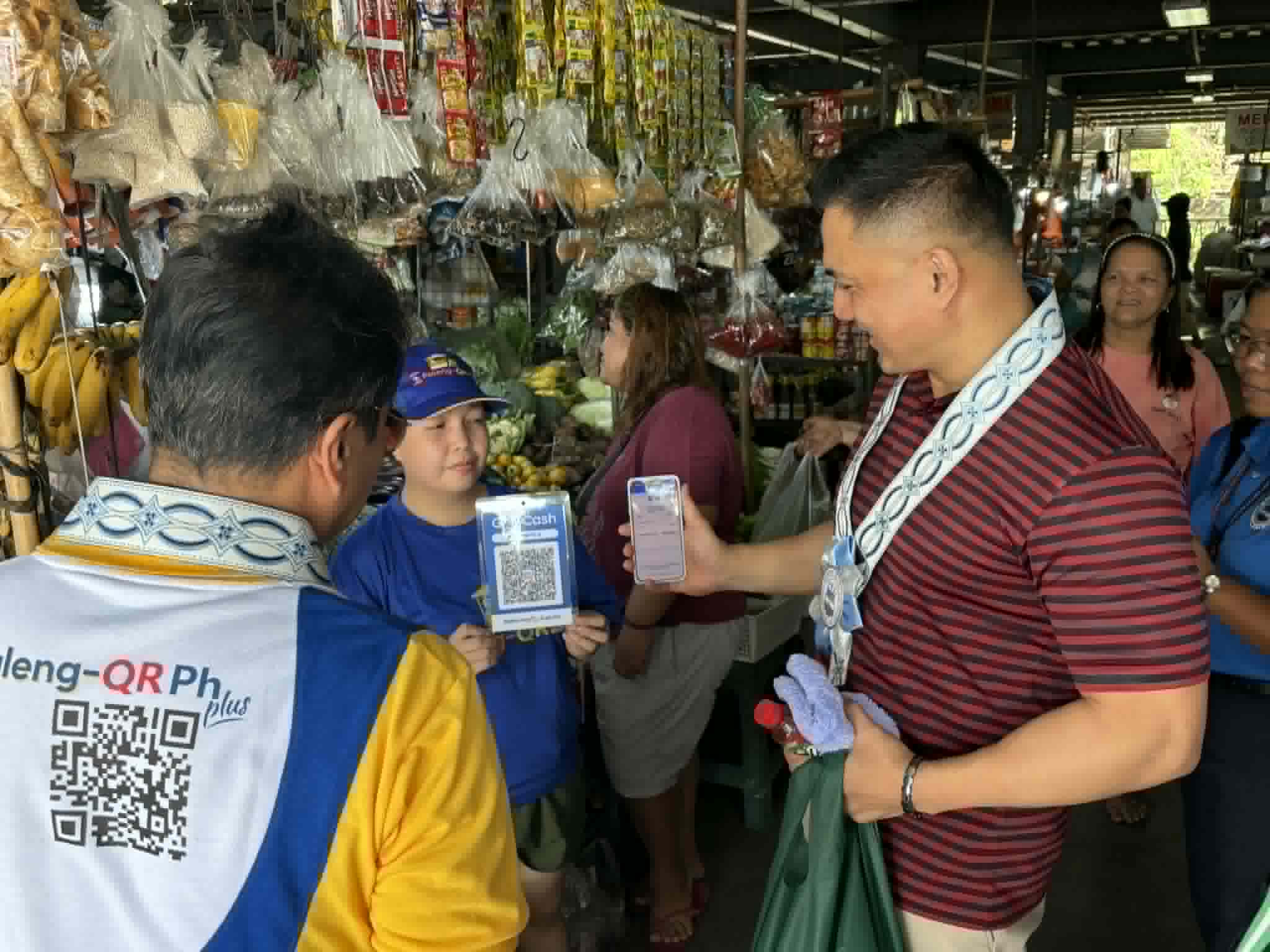 Mayor Jun Omar Ebdane buys products at a stall at the Botolan Public Market during the launch of the Paleng-QR PH Plus in the town of Botolan, Zambales on April 29, 2026.