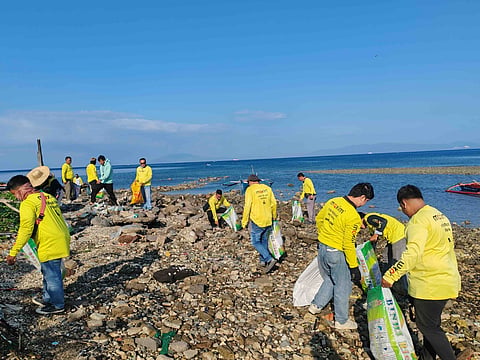 CLEANUP volunteers from Maxim and Barangay Tabangao Aplaya collect coastal waste during the company’s Earth Day activity in Batangas City.