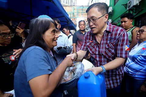 SENATOR Christopher ‘Bong’ Go shakes hands with a Tondo resident who received his assistance.